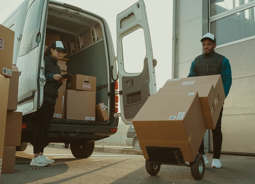 Delivery driver carrying boxes from van for direct store delivery