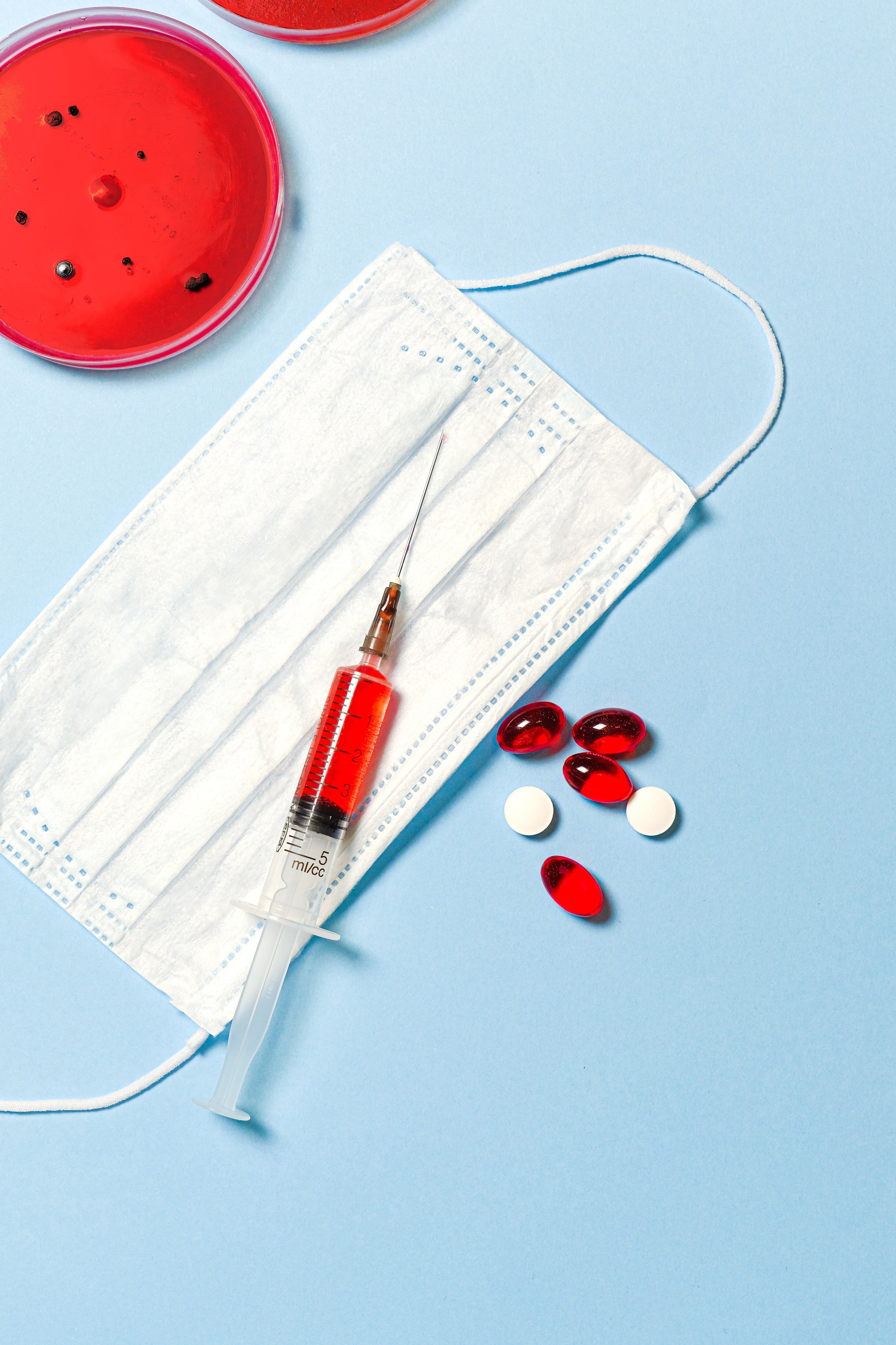 syringe-and-pills-on-blue-background-3786157
